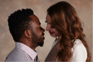 couple looks toward each other in portrait by Andrae Michaels portrait studios