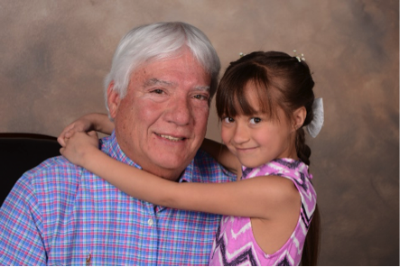granddaughter and grandfather smile for professional portrait