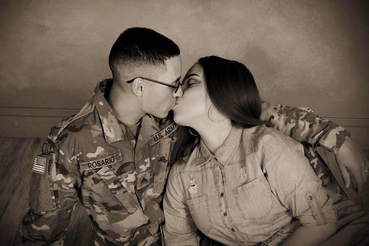military couple kiss for the camera at Andrae Michaels portrait studios